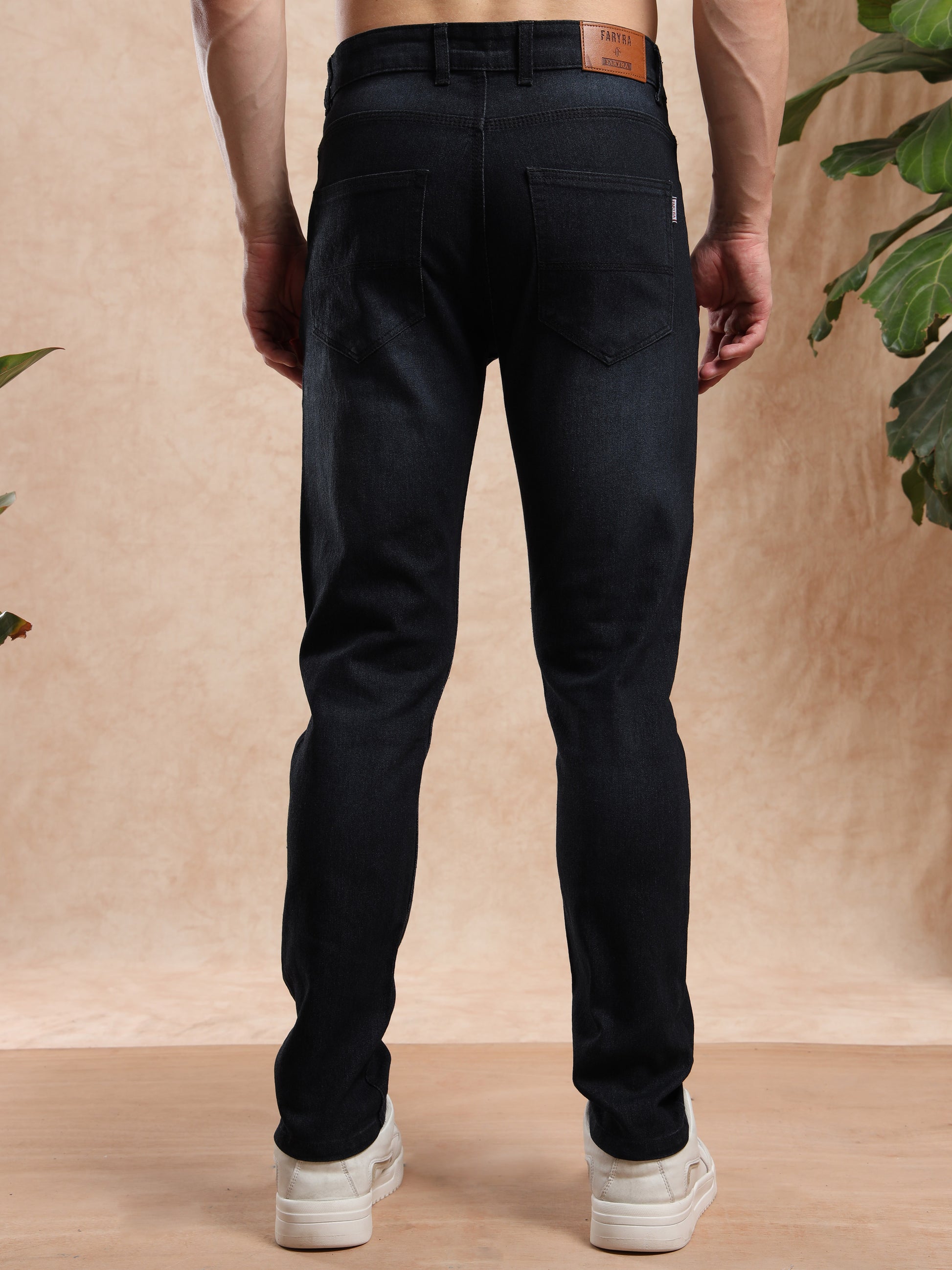 Person wearing black pants with a neutral background