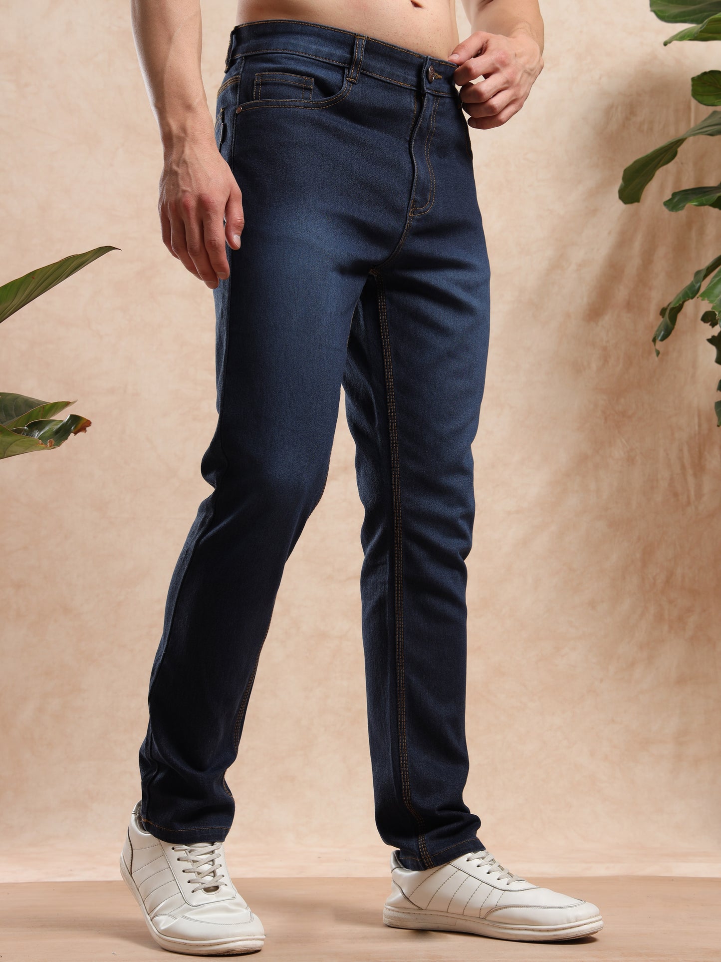 Slim fit dark blue men, jeans styled with white chunky sneakers, streetwear style