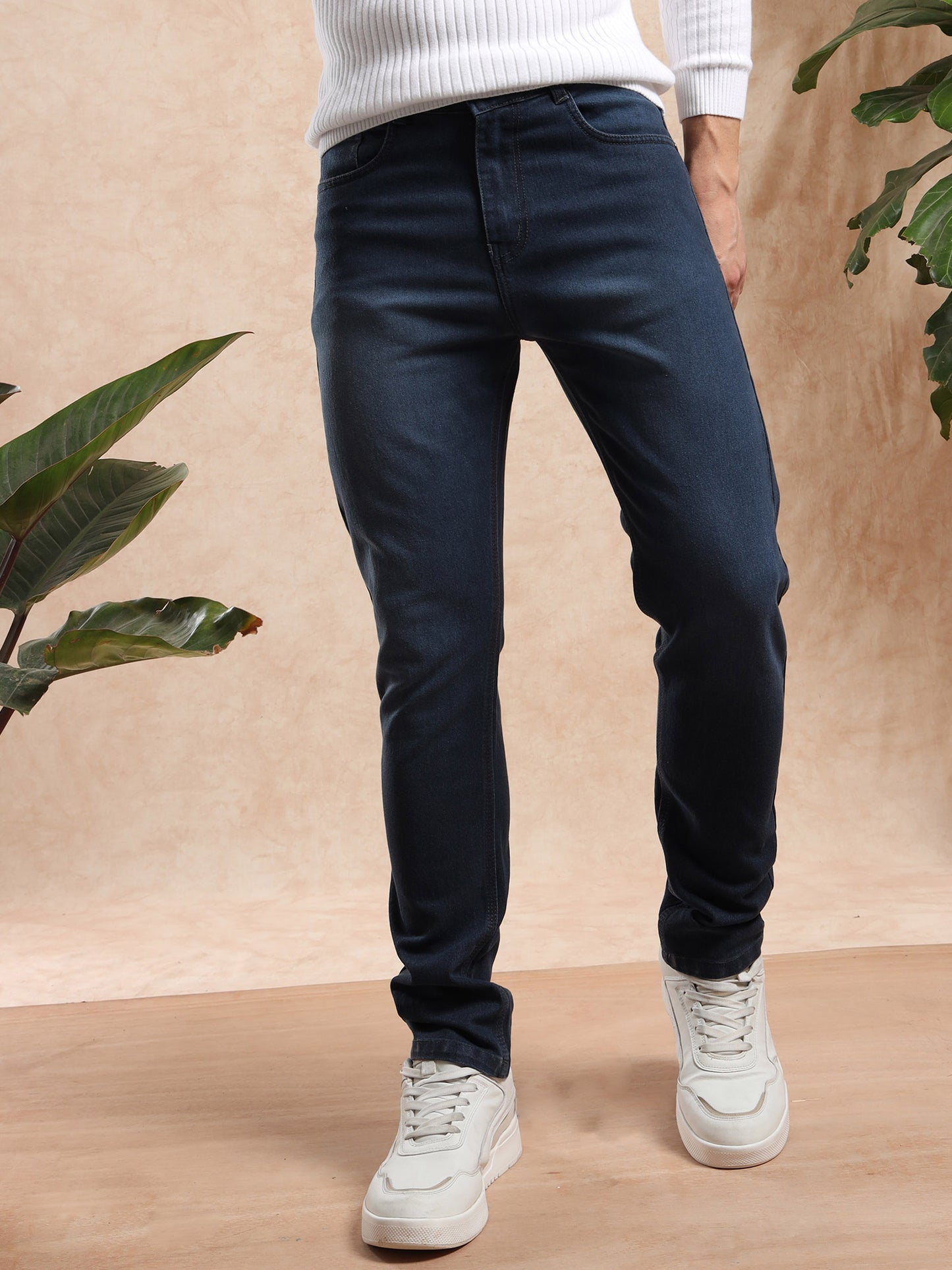 Men slim fit dark wash denim jeans paired with white sneakers, front view.