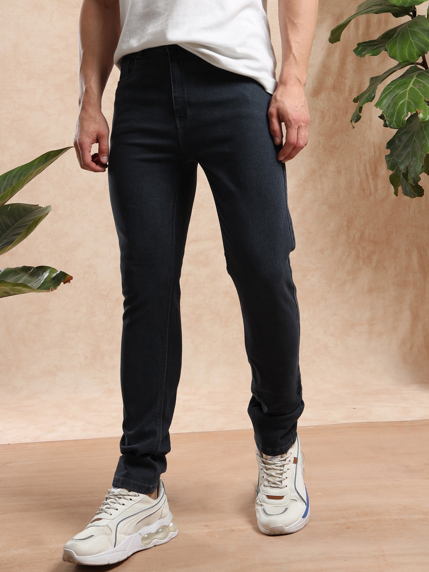 Men slim fit black denim jeans styled with white sneakers and casual tee  modern look