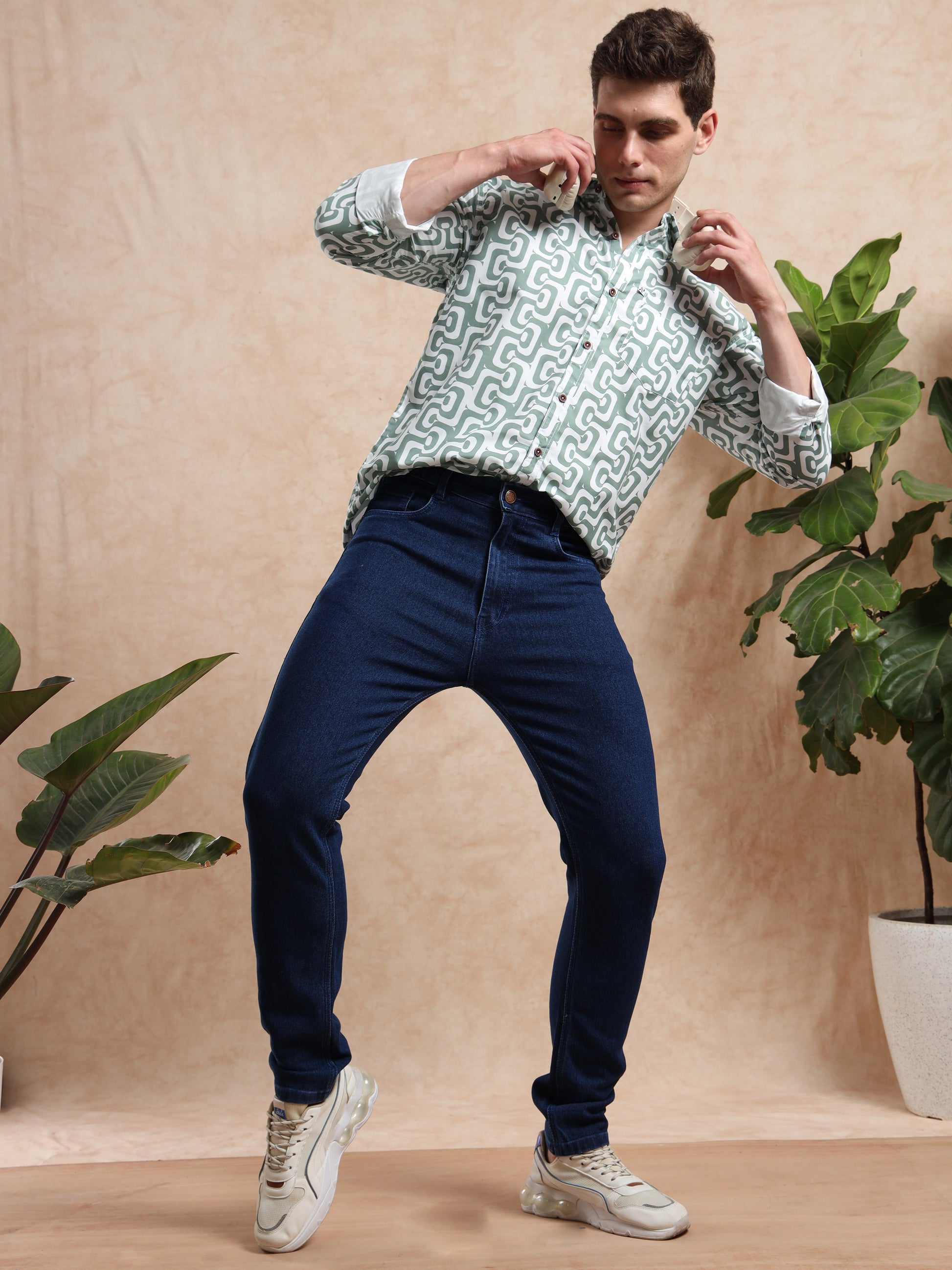 Men, slim fit dark blue denim jeans styled with printed shirt and sneakers, modern casual fashion