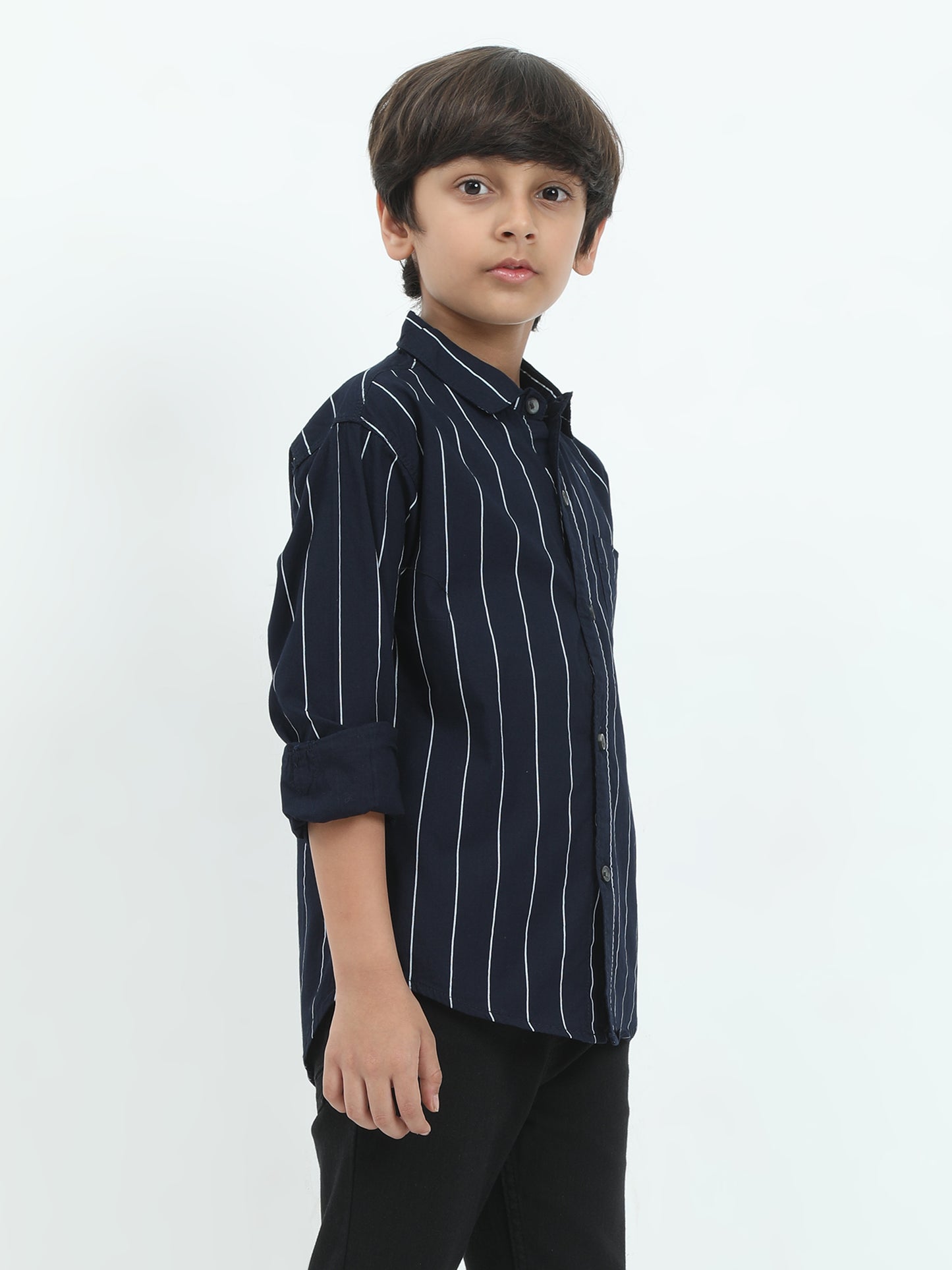 Young boy wearing a navy blue striped shirt on a white background