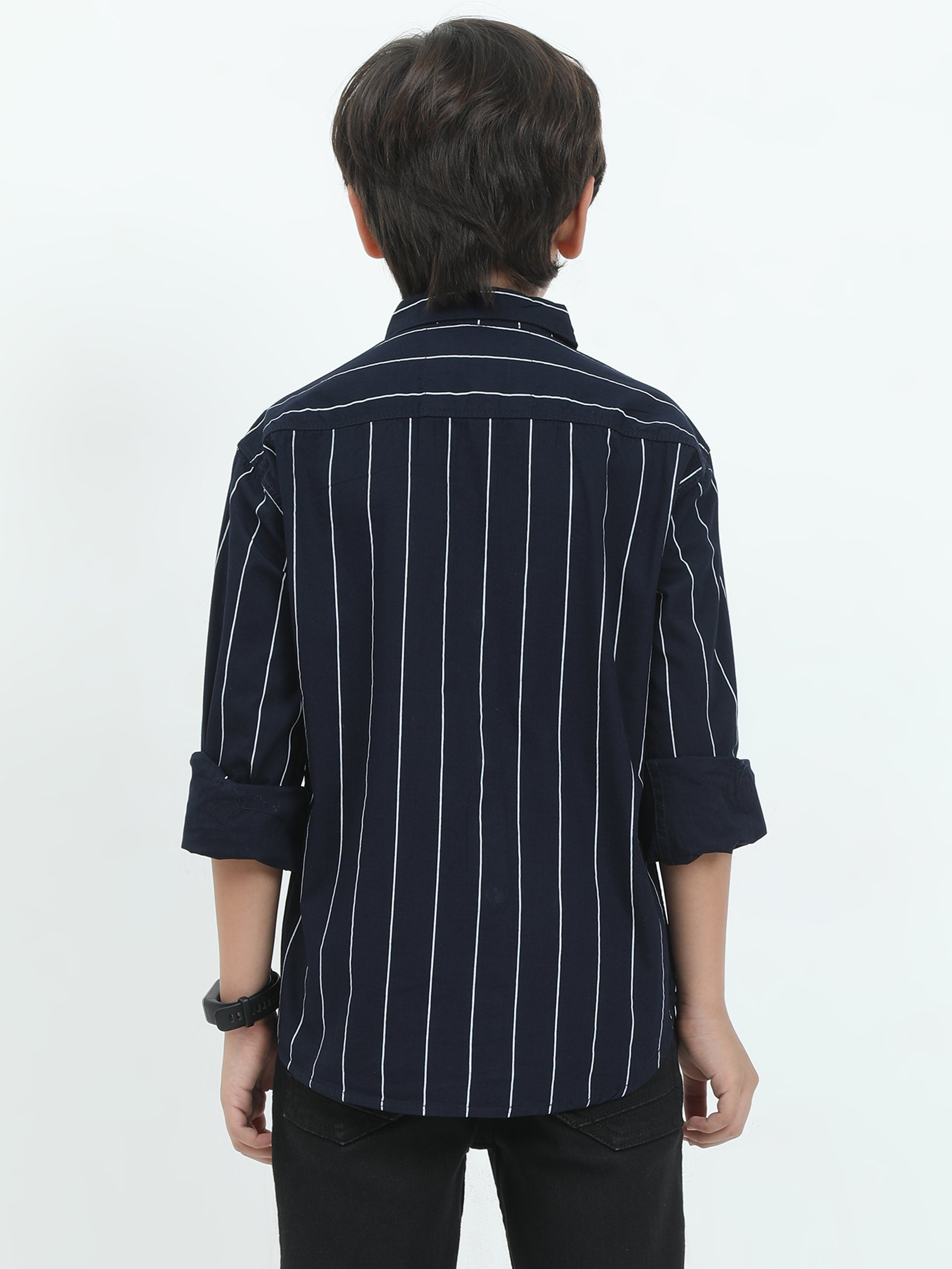Person wearing a navy blue striped shirt with rolled-up sleeves on a white background