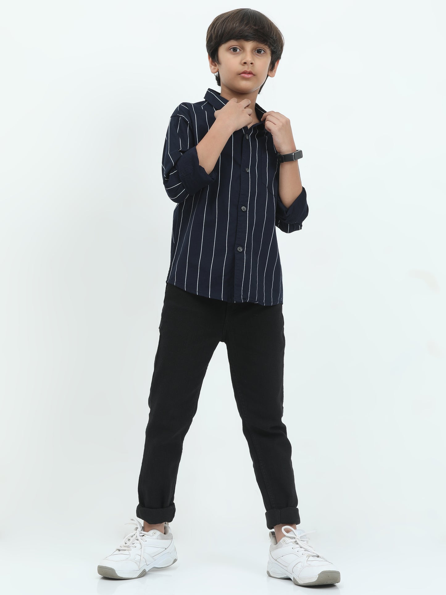 Child wearing a navy striped shirt and black pants on a white background