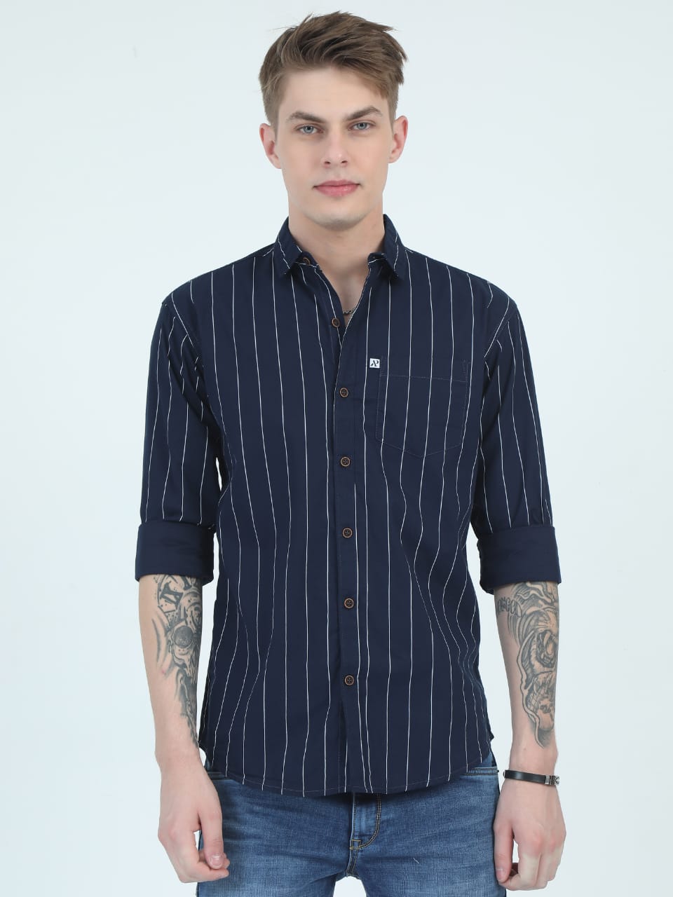 Man wearing a navy blue striped shirt against a white background
