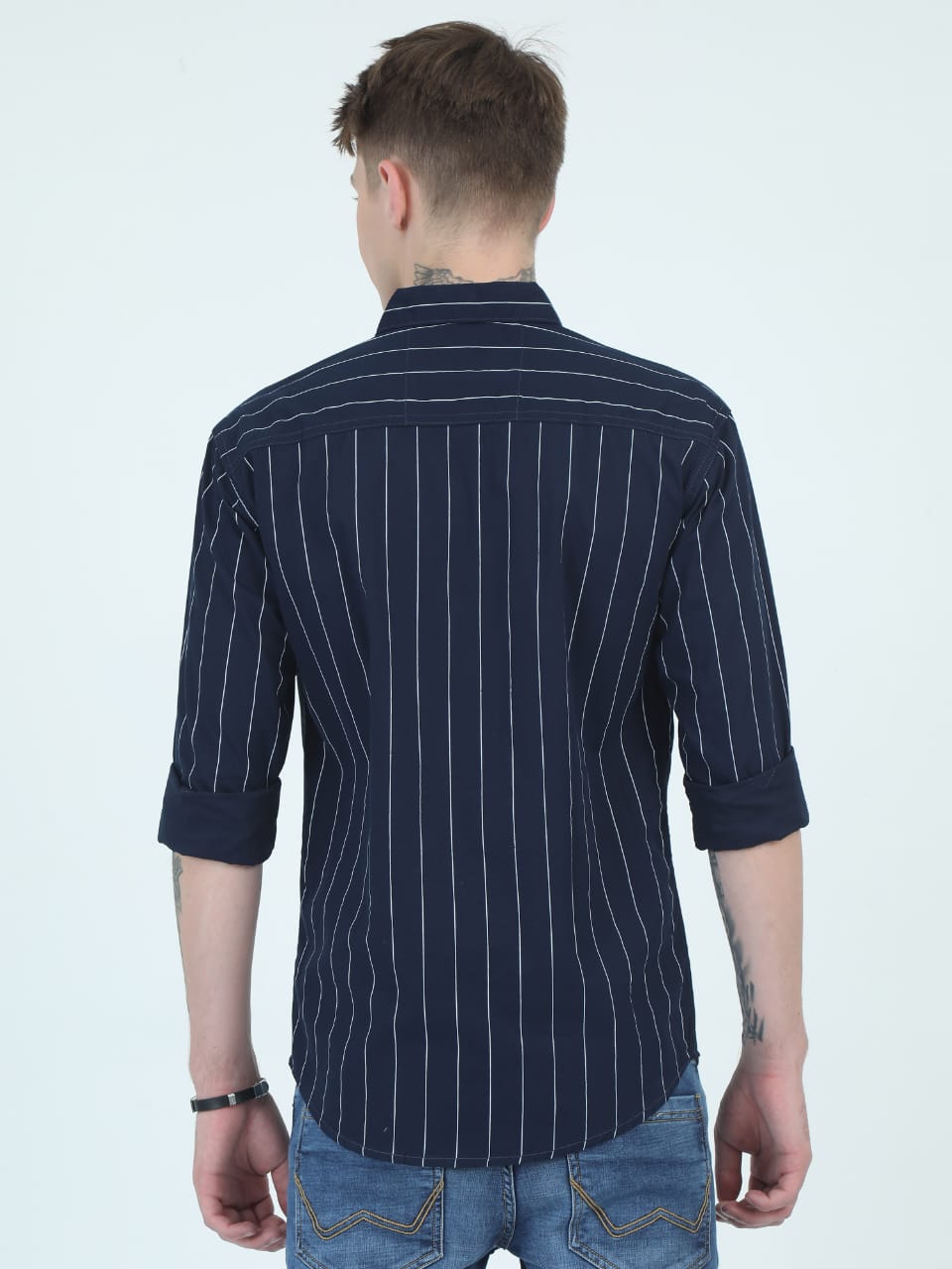 Man wearing a navy pinstripe shirt on a white background