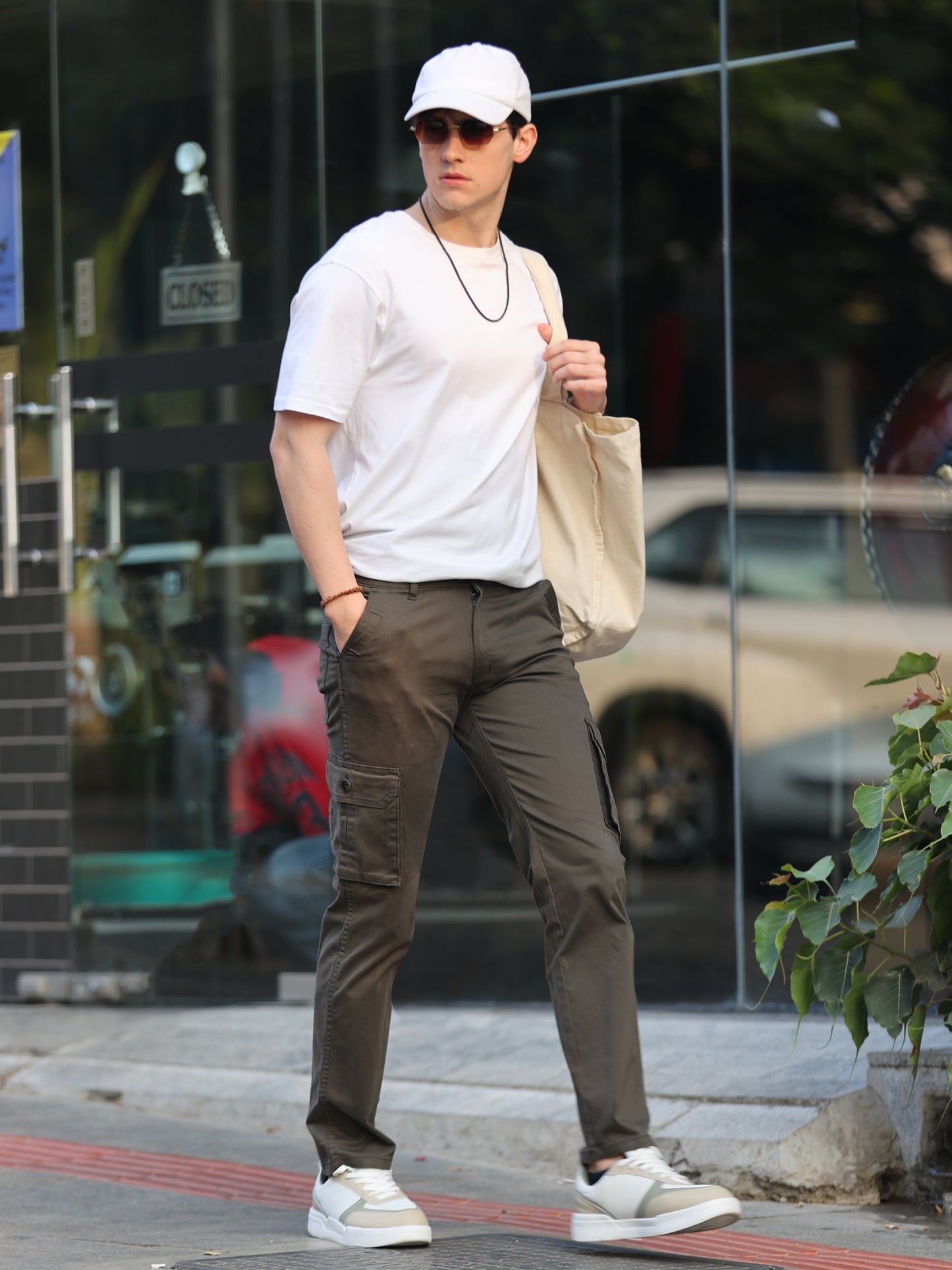 Casual men's olive green cargo pants paired with black sneakers studio look