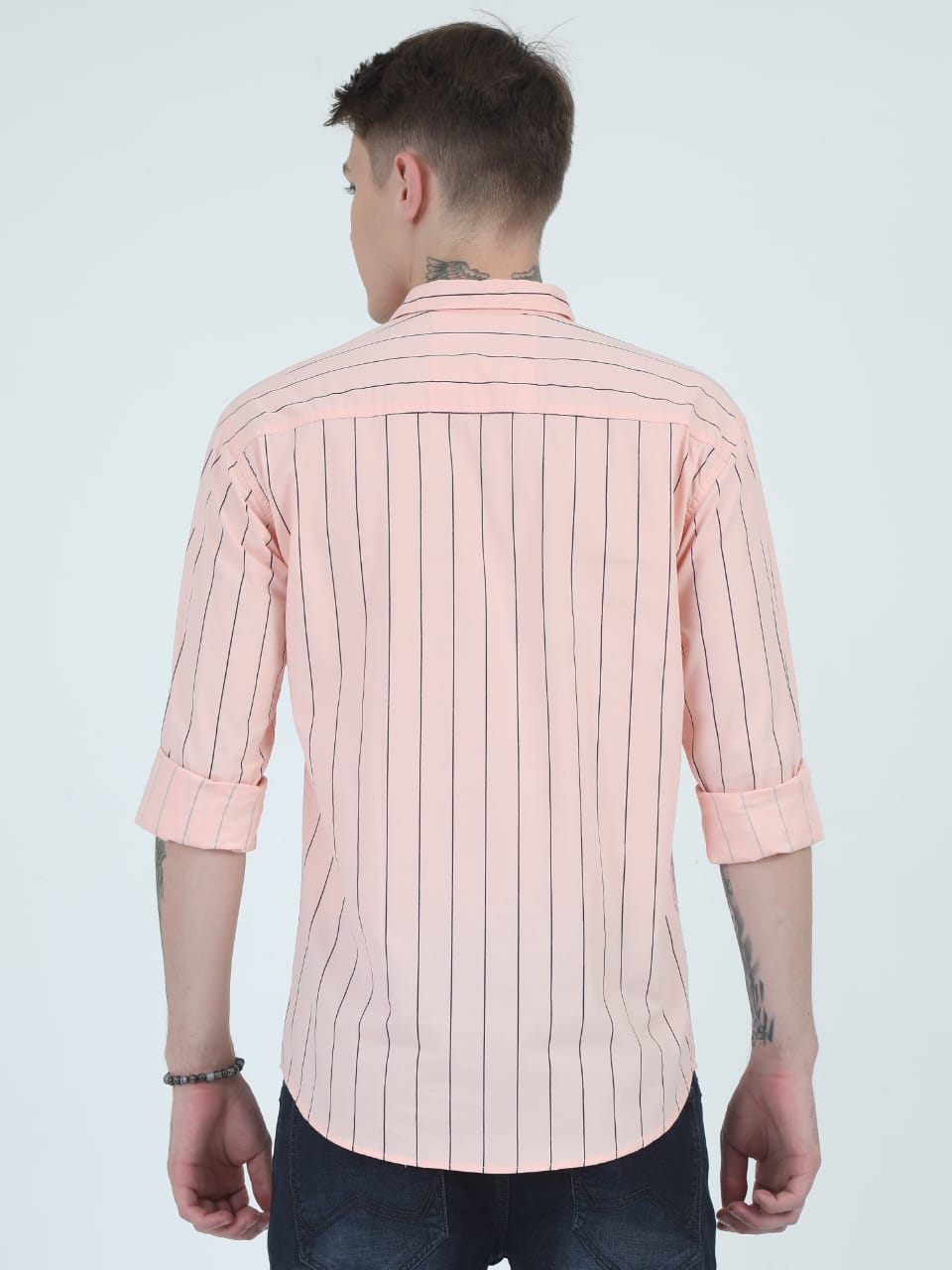 Man wearing a light pink striped shirt on a white background