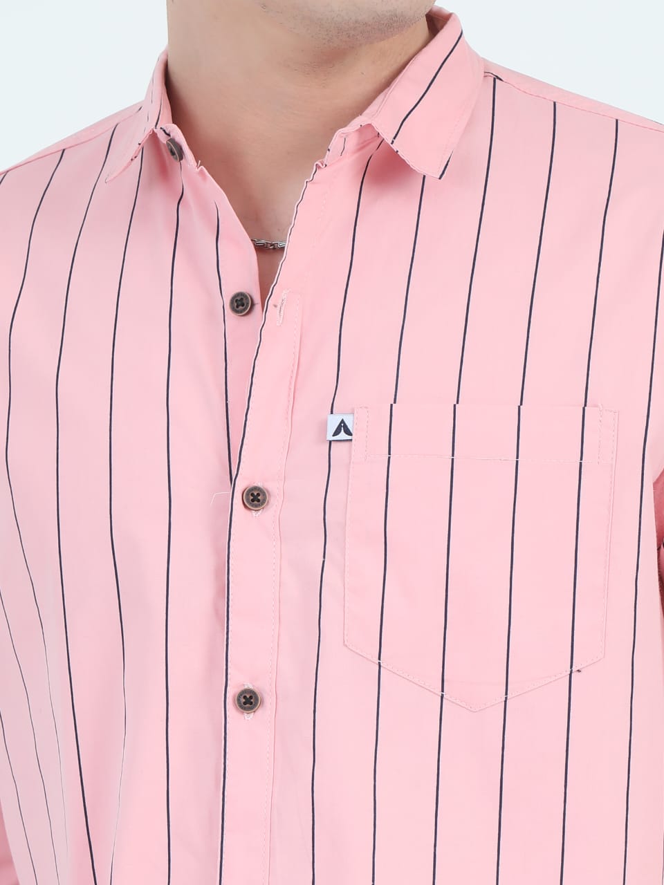 Close-up of a pink shirt with black vertical stripes on a white background