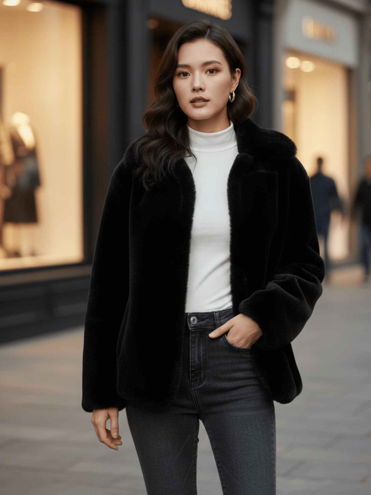 woman wearing a black faux fur jacket over a white turtleneck