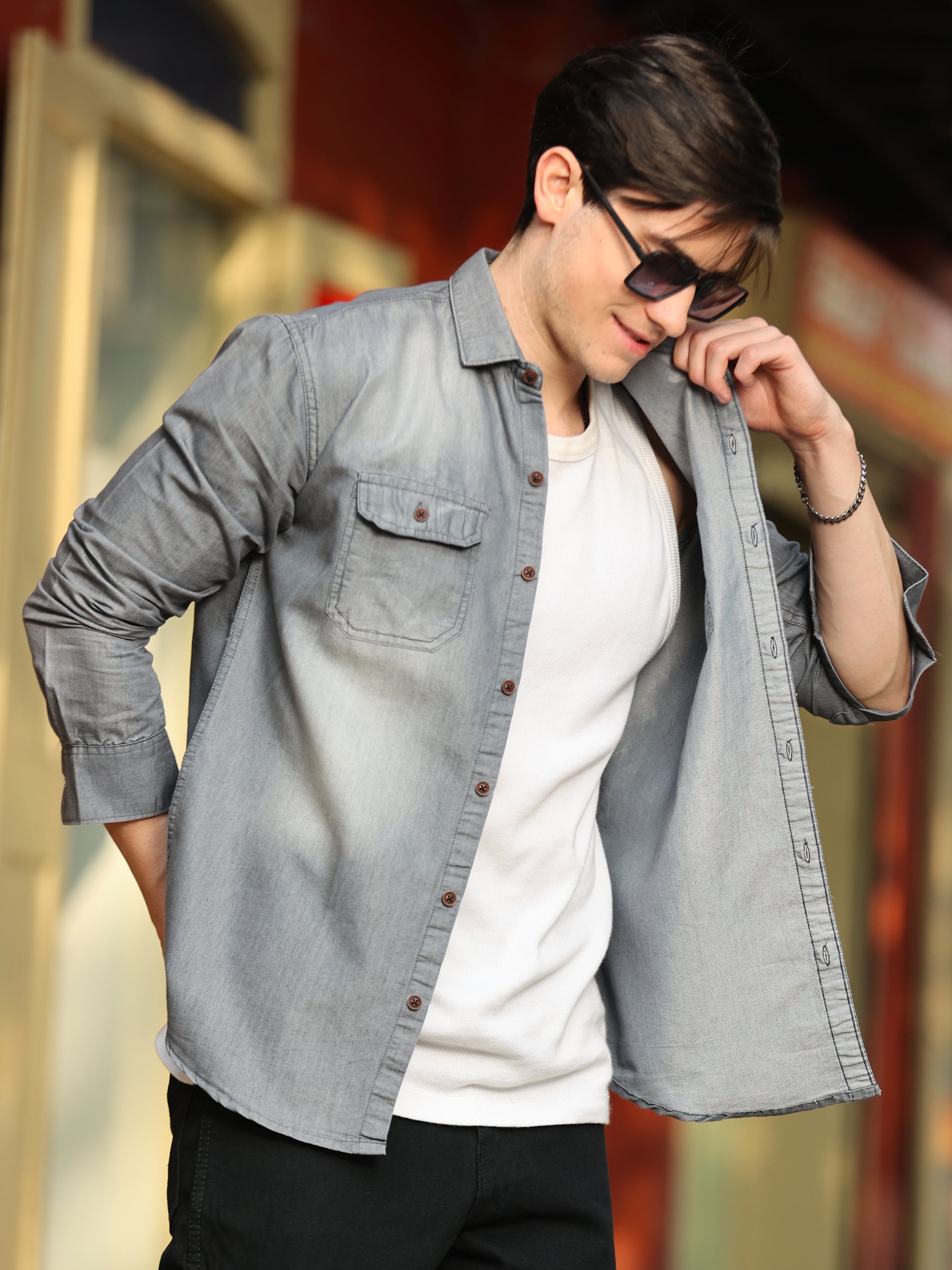 grey denim shirt for men paired with black pants in studio background