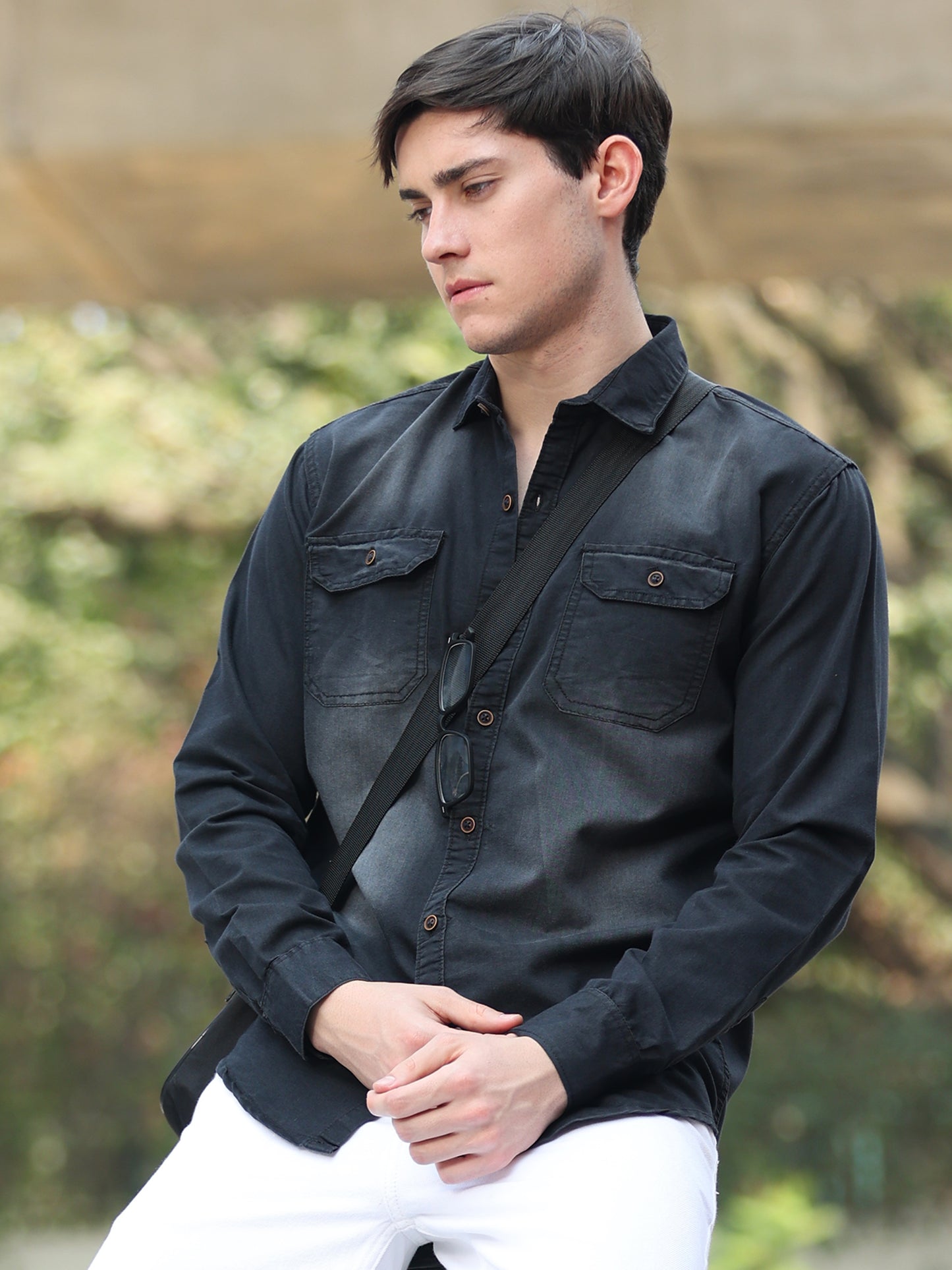 Stylish men wearing black faded denim shirt with button-down front and rolled sleeves