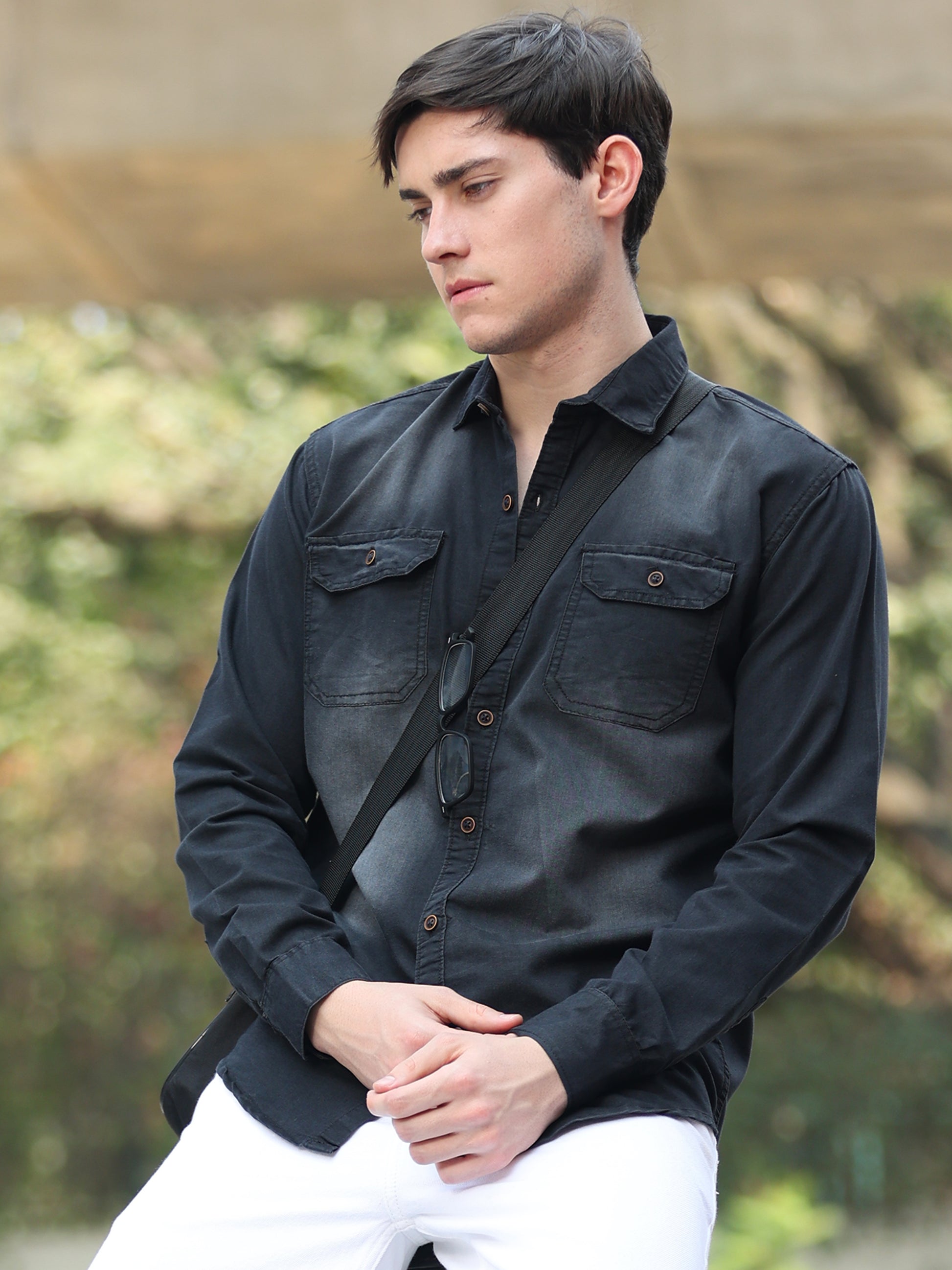 Stylish men wearing black faded denim shirt with button-down front and rolled sleeves