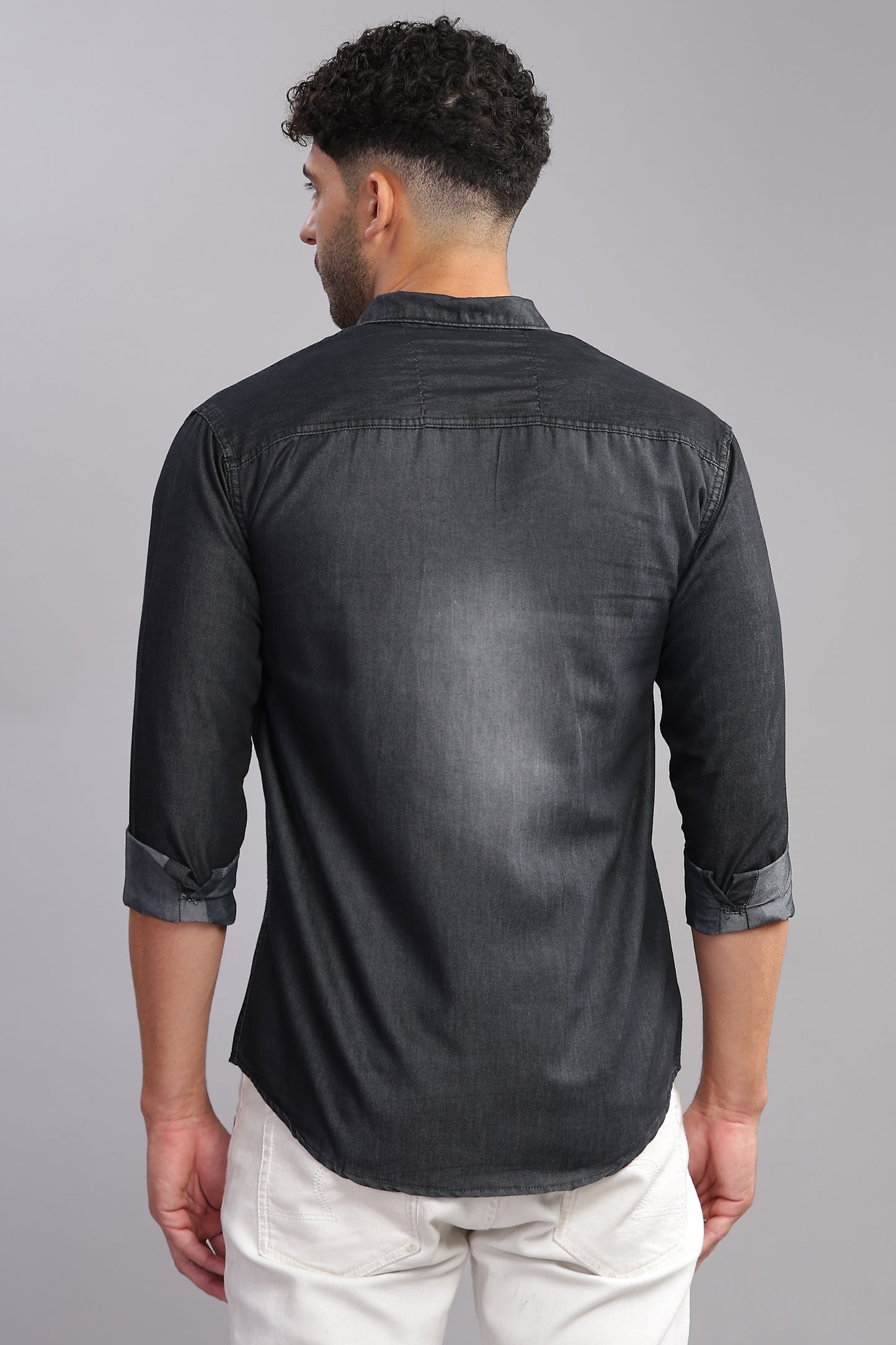 Men wearing dark grey denim shirt paired with white pants studio shoot
