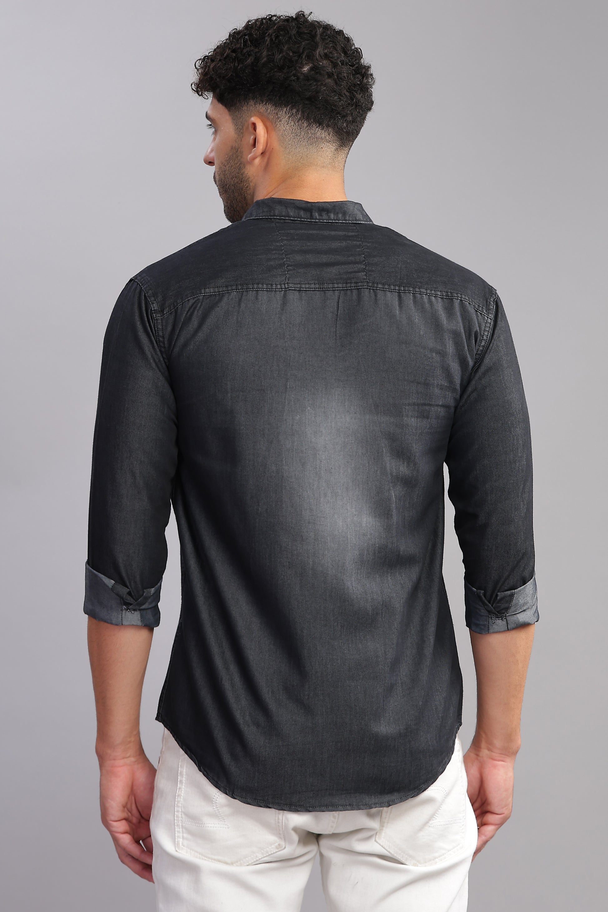 Men wearing dark grey denim shirt paired with white pants studio shoot