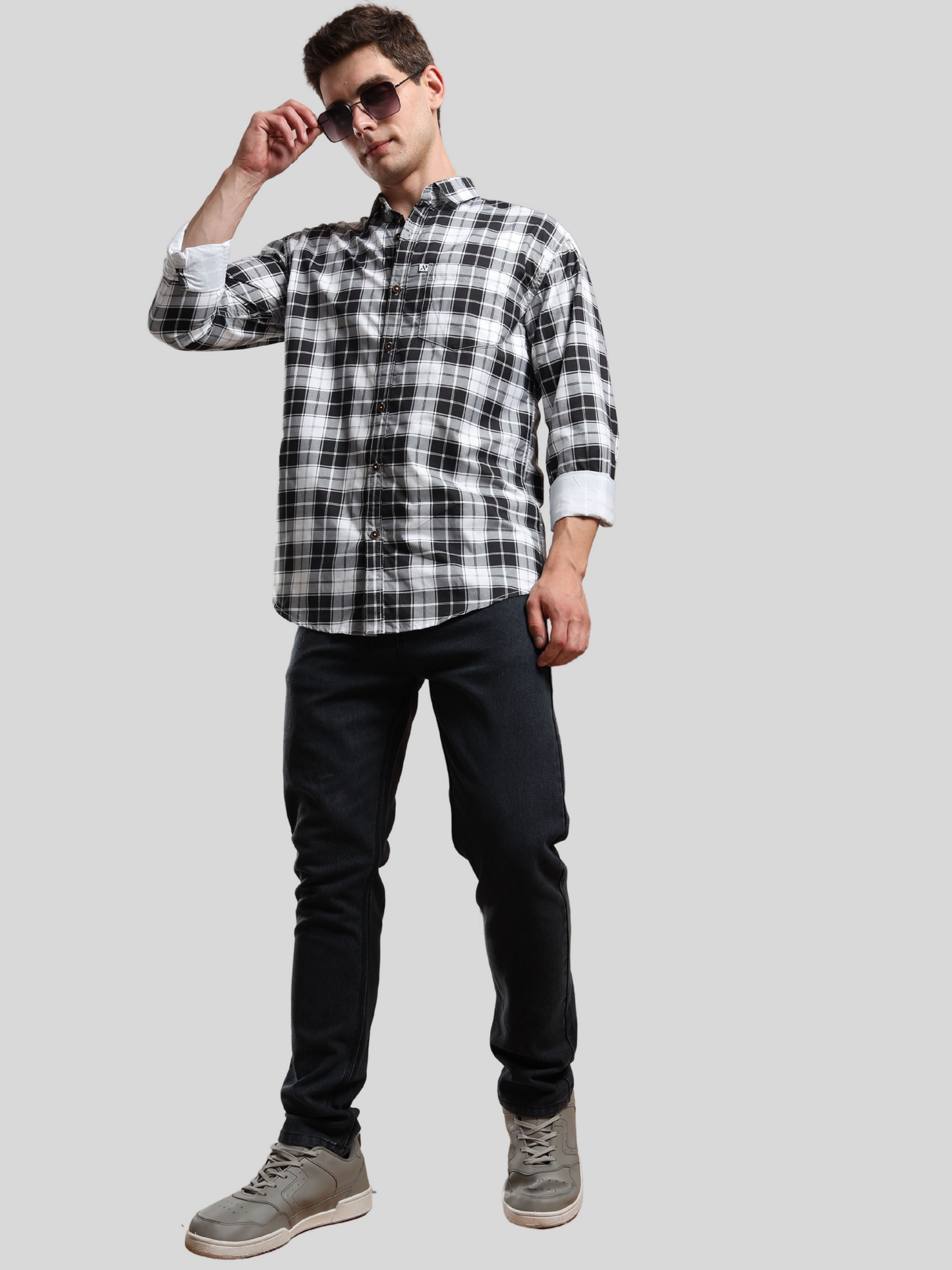 black and white checked shirt paired with jeans and sneakers