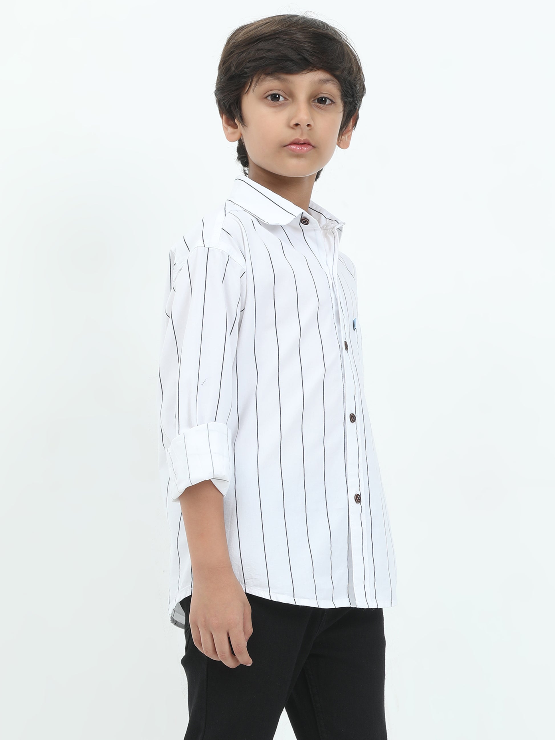 Young boy wearing a white striped shirt and black pants on a white background
